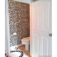 a bathroom with black and white animal print wallpaper on the walls, along with a toilet