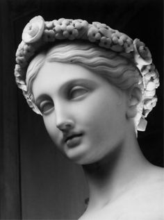 a black and white photo of a woman's head with flowers in her hair