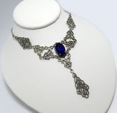 "This is a new handmade necklace. It is made with antiqued silver plated filigrees, accented with a high quality DARK COBALT BLUE glass rhinestone. Decorated portion is 6\" wide and 3 1/4\" tall in the center. Necklace is adjustable 15-18\" with a lobster clasp and chain extender. If you would like a different length, please send us a message." Gothic Metal Jewelry With Filigree, Gothic Filigree Metal Jewelry, Antique Silver Gothic Filigree Jewelry, Antique Silver Gothic Jewelry With Filigree, Gothic Antique Silver Filigree Jewelry, Gothic Sterling Silver Filigree Jewelry, Gothic Nickel-free Jewelry For Weddings, Gothic Nickel-free Wedding Jewelry, Blue Gothic Metal Necklace