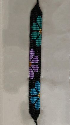 a beaded tie with flowers is hanging on the wall