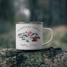 a campfire mug sitting on top of a tree stump with the words adventure await written on it