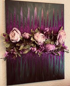 a painting with purple flowers and green leaves on the bottom, in front of a white wall