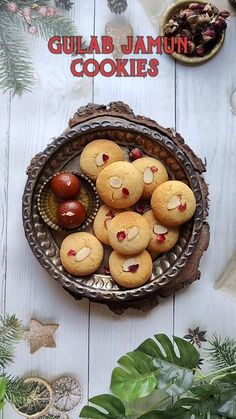 some cookies are in a bowl on a table with christmas decorations and greenery around it