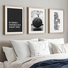 three black and white pictures hang on the wall above a bed with pillows, blankets and throw pillows