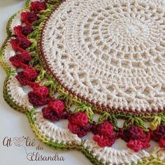 crocheted placemats with red and green flowers on them