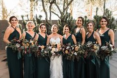 a group of women standing next to each other wearing green dresses and holding bouquets