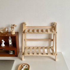 a wooden shelf sitting on top of a white counter next to a cutting board and scissors