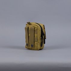 a small yellow bag sitting on top of a white table next to a gray wall