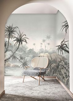 a chair sitting on top of a rug in front of a wall with palm trees