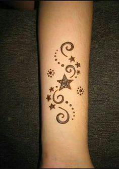 a person with a tattoo on their arm that has stars and swirls on it