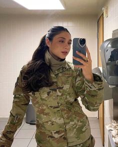 a woman in uniform taking a selfie with her phone