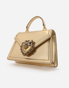 This small top-handle bag from the Devotion line comes in materials that are perfect for special occasions. Made from nappa mordore leather; it features the exclusive bejeweled heart fastening and the shoulder strap inspired by the techniques of high quality jewelers. Top handle and detachable shoulder strap Front flap with bejeweled branded heart hand-tooled from a metal alloy with pearl inlay Concealed magnetic fastening and customized heart Calfskin interior with flat pocket Item comes with i Woman Shoulder, Pearl Inlay, Heart Hands, Gold Leather, Small Tops, Top Handle, Crossbody Bags, Calf Skin, Dolce And Gabbana