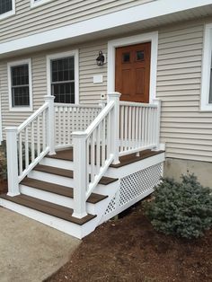 a white porch with steps leading up to the front door