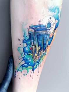 a watercolor tattoo on the leg of a person with a blue tardish