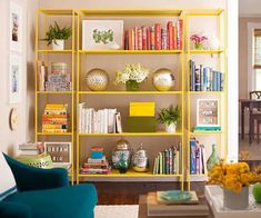 a living room filled with furniture and bookshelves next to a dining room table