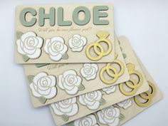 three wooden magnets with gold rings and roses on them