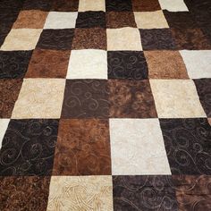 a brown and white checkered quilt on the floor