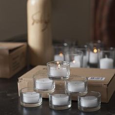 candles are arranged on a table in front of a box