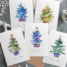 four christmas cards with watercolor trees on them