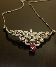 DeKara Designs A Beautiful Timeless 14K White Gold Art Deco Inspired Ruby Diamond Necklace. Metal- 14K White Gold, .583. Stones- 1 Pear Shape Pinkish Red Ruby 0.90 Carats, 2 Round Rubies 0.27 Carats, 44 Round Antique Diamonds G-H Color VS2-SI1 Clarity 1.10 Carats. Handmade Diamond Art Deco Influcned Ruby Diamond Necklace. I have used authentic antique Old European Cut and Miner's Cut diamonds for this necklace. The necklace features a beautiful pear shape ruby that is dangling on the bottom of t Collectible Diamond Necklace Fine Jewelry, Elegant Gemstone Necklace For Collectors, Diamond Pendant Necklace For Collectors, Elegant Diamond Necklace For Ceremonial Occasions, Luxury White Gold Necklace For Ceremonial Occasions, Elegant Necklaces With Intricate Design For Collectors, Elegant Intricate Design Necklaces For Collectors, Elegant Collectible Necklaces With Intricate Design, Elegant Intricate Collectible Necklaces