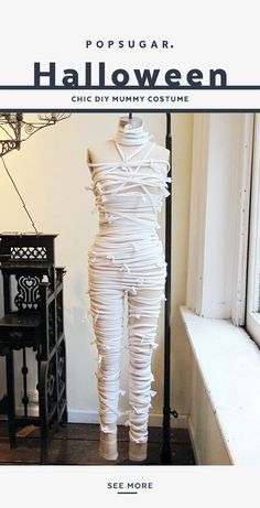 a mannequin made out of white paper in front of a window with the words popsugar halloween on it