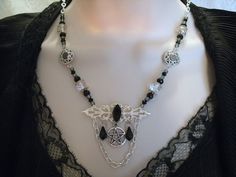 "This beautiful necklace has a black faceted glass setting on a sterling silver plated filigree pendant, a pewter silver pentacle, czech glass beads, seed beads, pewter silver bead caps, pewter silver filigree accents, black crystal drops and metal chain. 18\" long. Toggle clasp." Gothic Pendant Jewelry For Festivals, Nickel Free Gothic Pendant Jewelry, Gothic Silver Necklaces For Festival, Gothic Nickel-free Pendant Jewelry, Nickel-free Gothic Pendant Jewelry, Gothic Wire Wrapped Pendant Jewelry, Gothic Silver Wire Wrapped Jewelry, Silver Metal Witchy Jewelry, Witchy Silver Metal Jewelry