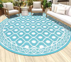 a blue and white area rug on a wooden floor in front of two couches