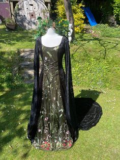 "TO CELEBRATE SAMHAIN  🕷FREE CHOKER 🕷  WITH THIS PURCHASE  THIS STUNNING ENCHANTED ORIGINAL HAND CRAFTED DRESS HAS BEEN  FASHIONED  IN THE PRINCESS LINE STYLE  IT IS MADE FROM IN A LUXURIOUS TRULY GORGEOUS MIDNIGHT BLACK CRUSHED VELVET  (CONTAINING LYCRA) ...    IDEAL FOR  A  MEDIEVAL / RENAISSANCE THEMED BALL, PARTIES, SAMHAIN / HALLOWEEN 🎃 , HANDFASTINGS / WEDDINGS, OR ANY SPECIAL, SACRED OCCASION, FOR THAT EXTRA WOW FACTOR   THE  FLOOR LENGHT MEDIEVAL STYLE SLEEVES HAVE BEEN MADE FROM A BEAUTIFUL BLACK LACE    THE FRONT PANEL BEEN FASHIONED FROM A STUNNING  BREATHTAKINGLY BEAUTIFUL EMBROIDERED FINE BLACK TULLE WITH A STUNNING GARDEN MEADOW FLOWER DESIGN WORTHY  OF WOODLAND KIN, FOR THAT EXTRA TOUCH OF ELEGANCE  OVERLAID OVER A BEAUTIFUL OLIVE GREEN CRUSHED VELVET   THE FRONT IS LACED Pagan Handfasting, Celebrate Samhain, Handfasting Wedding, Garden Meadow, Historical Costuming, Samhain Halloween, Princess Line, Medieval Style, Fantasy Dresses