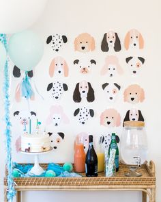 a party table with balloons, confetti and paper poodles on it