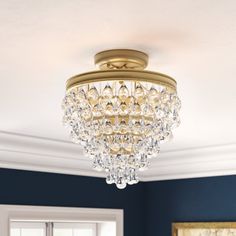 a chandelier hanging from the ceiling in a room with blue walls and white trim