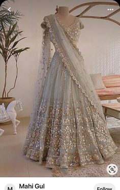 a mannequin is dressed up in a silver lehenga with gold sequins