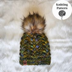 a knitted hat with a fur pom in the center on a white background