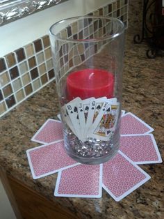 a candle and some playing cards on a counter