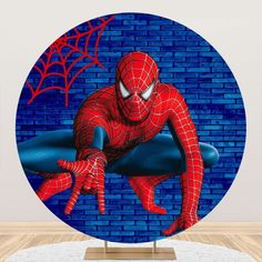 a spider man sitting on top of a blue brick wall