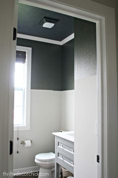 a white toilet sitting in a bathroom next to a window