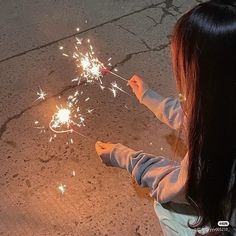 a girl is holding sparklers in her hands