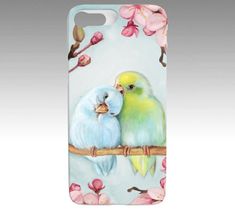 two birds are sitting on a branch with pink flowers