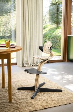 a chair that is sitting on top of a rug in front of a table and window