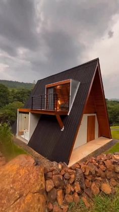 a small house on top of a hill with a roof made out of wood and metal