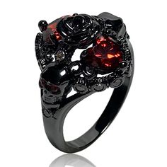 a black ring with red stones in the center and two skulls on it's sides