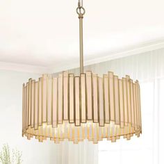 a chandelier hanging from the ceiling in a living room with white walls and curtains