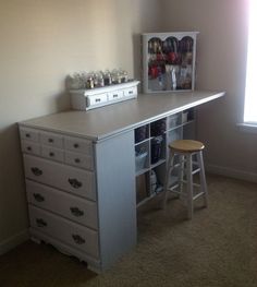 a white desk with several drawers and stools