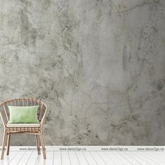 a chair sitting in front of a wall with a green pillow on top of it