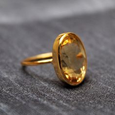 Faceted Oval Topaz Ring Gift, Classic Oval Citrine Rings, Oval Citrine Gemstone Ring, Oval Citrine Amber Rings, Oval Amber Citrine Ring, Amber Citrine Oval Ring, Yellow Oval Rings With Bezel Setting, Amber Oval Birthstone Ring, Yellow Oval Ring With Bezel Setting