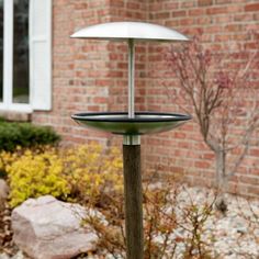 a bird feeder in front of a brick house