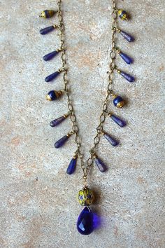 "Cobalt blue Czech glass drops paired with Tibetan beads and a vintage teardrop crystal on a gold chain. 32\" chain with a 2\" pendant. Lobster claw clasp. Handmade. One of a kind." Blue And Gold Necklace, Long Necklaces, Blue And Gold, Lobster Claw, Cobalt Blue, Czech Glass, Long Necklace, Gold Chain, Gold Chains