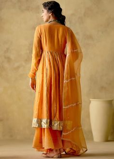 Features a tangerine front open silk anarkali embellished with zari & patra work, finished with gota lace & button detailing on the front. Completed with a matching sharara with lace detailing and an embellished dupatta. Composition : Anarkali & Sharara: Chanderi Silk Lined with Mul Cotton, Dupatta: Organza Care: Dry Clean Only and Vacuum Storage All products can be customised for sleeves, length of blouse and neck design Delivery : 3-4 weeks as the product is hand crafted. Check Size Guide or choose MySize for free customisation (All Sizes above XL can be made at 15% additional cost) For more information and sizes please contact fabiliciousfashion@gmail.com or visit our Copenhagen studio.