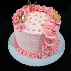 a pink and gold decorated birthday cake on a white plate