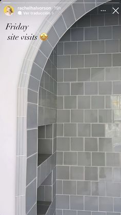 a white toilet sitting next to a walk in shower under a tiled wall with shelves