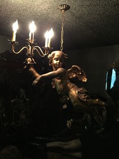 a chandelier hanging from the ceiling in a dark room with candles on it